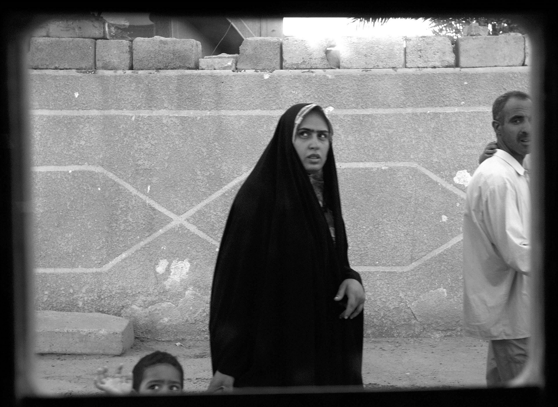Bagdad, 2014. Una mujer y su pequeño hijo miran fijo al soldado sobre la superficie del transporte militar estadounidense desde donde Gilkey tomó la fotografía