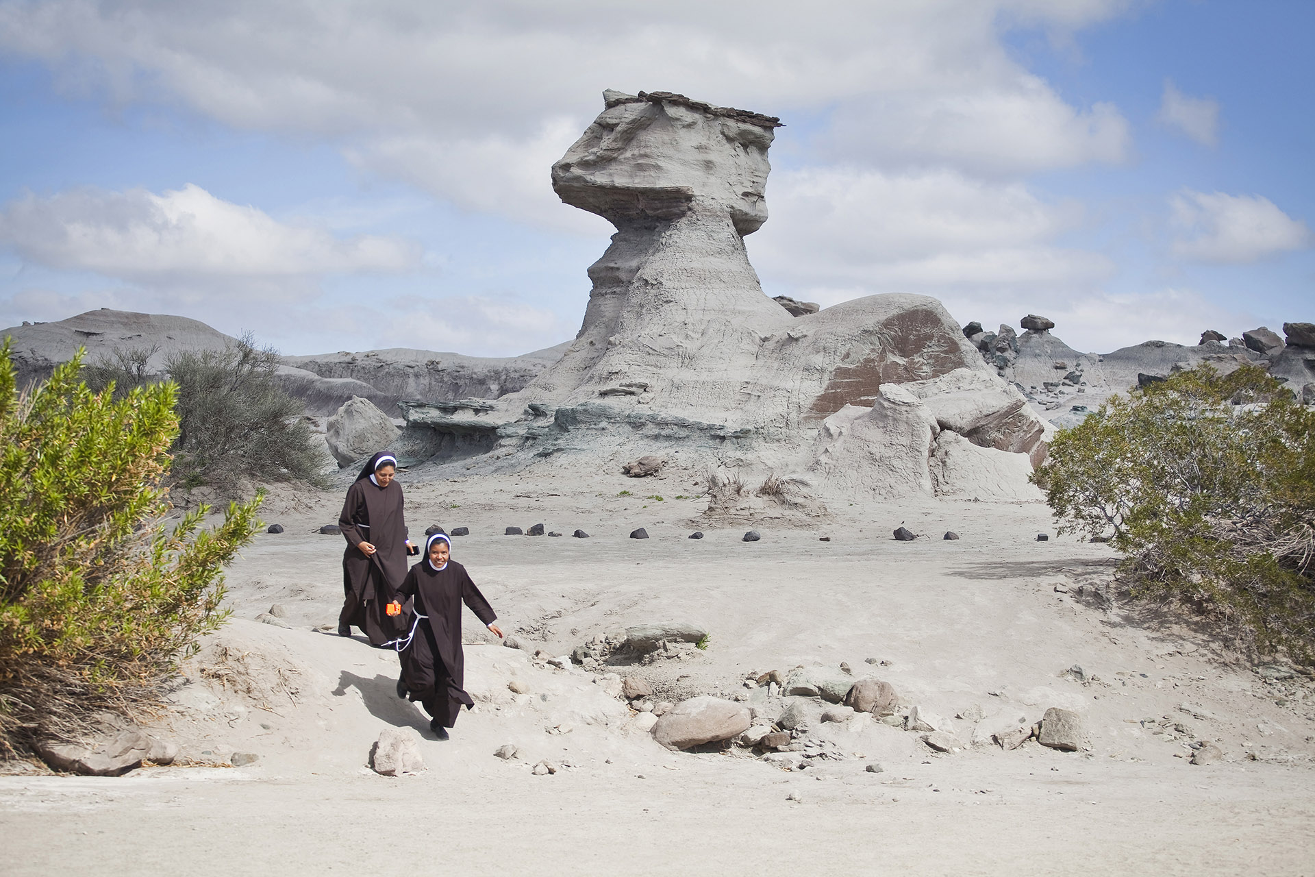 Dos monjas pasan frente a ‘La esfinge’, en el Valle de la Luna, cuando vuelven de la visita a la ‘Cancha de Bochas” (Cristian Andres Lozano)