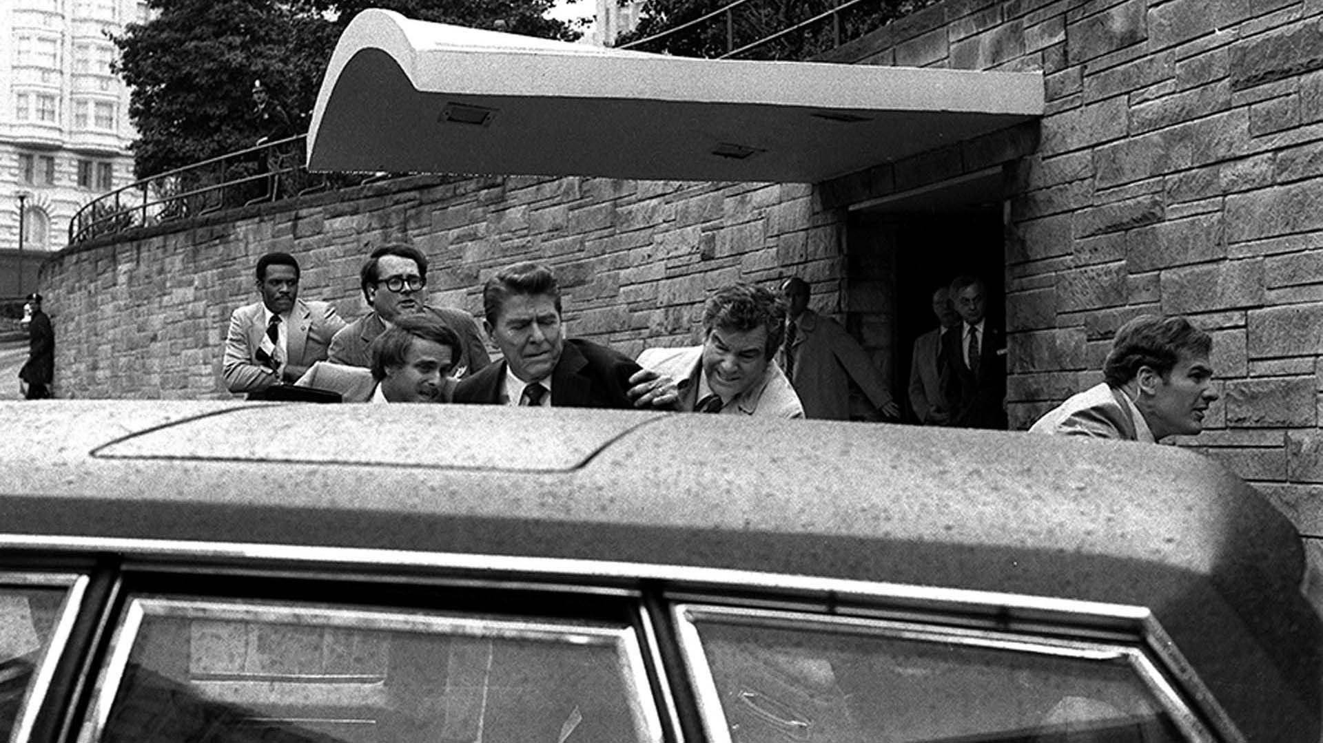 Jerry S. Parr, a la derecha de Ronald Reagan, en el instante previo a introducir al ex presidente estadounidense en la limusina oficial
