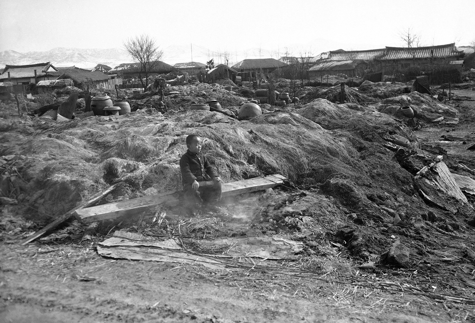 Un niño sentado en las humeantes ruinas de su casa destruida por el fuego en la zona de Suwon el 3 de febrero de 1951, cuando las tropas aliadas quemaron viviendas que podrían proporcionar refugio a las tropas rojas (AP)