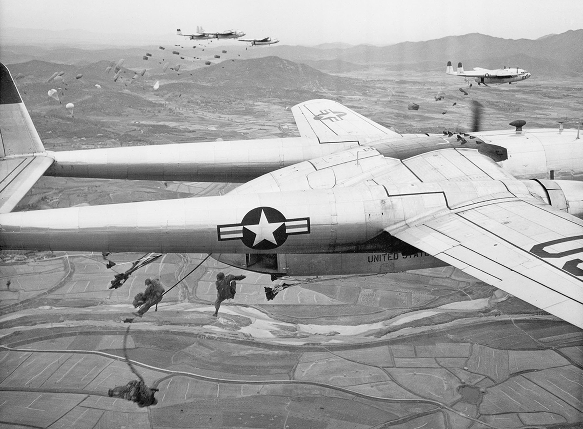 Paracaidistas caen de aviones de transporte de la Fuerza Aérea de EE.UU. C-119 durante una operación sobre un lugar no revelado en Corea, en octubre de 1950 (AP)