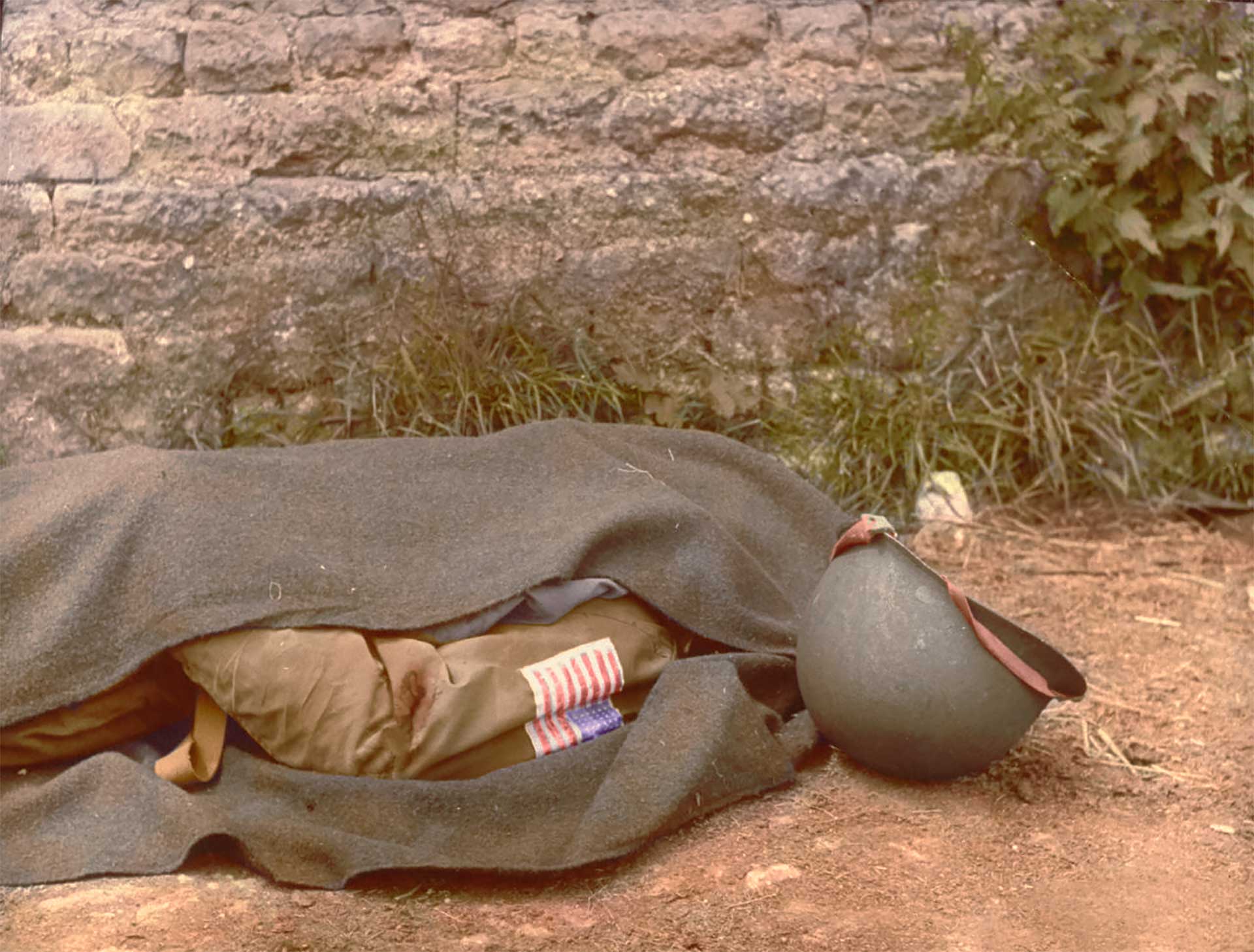 El cuerpo de un paracaidistas es cubierto con una manta. Ocurrió el 7 de junio de 1944, un día después del Desembarco en Normandía