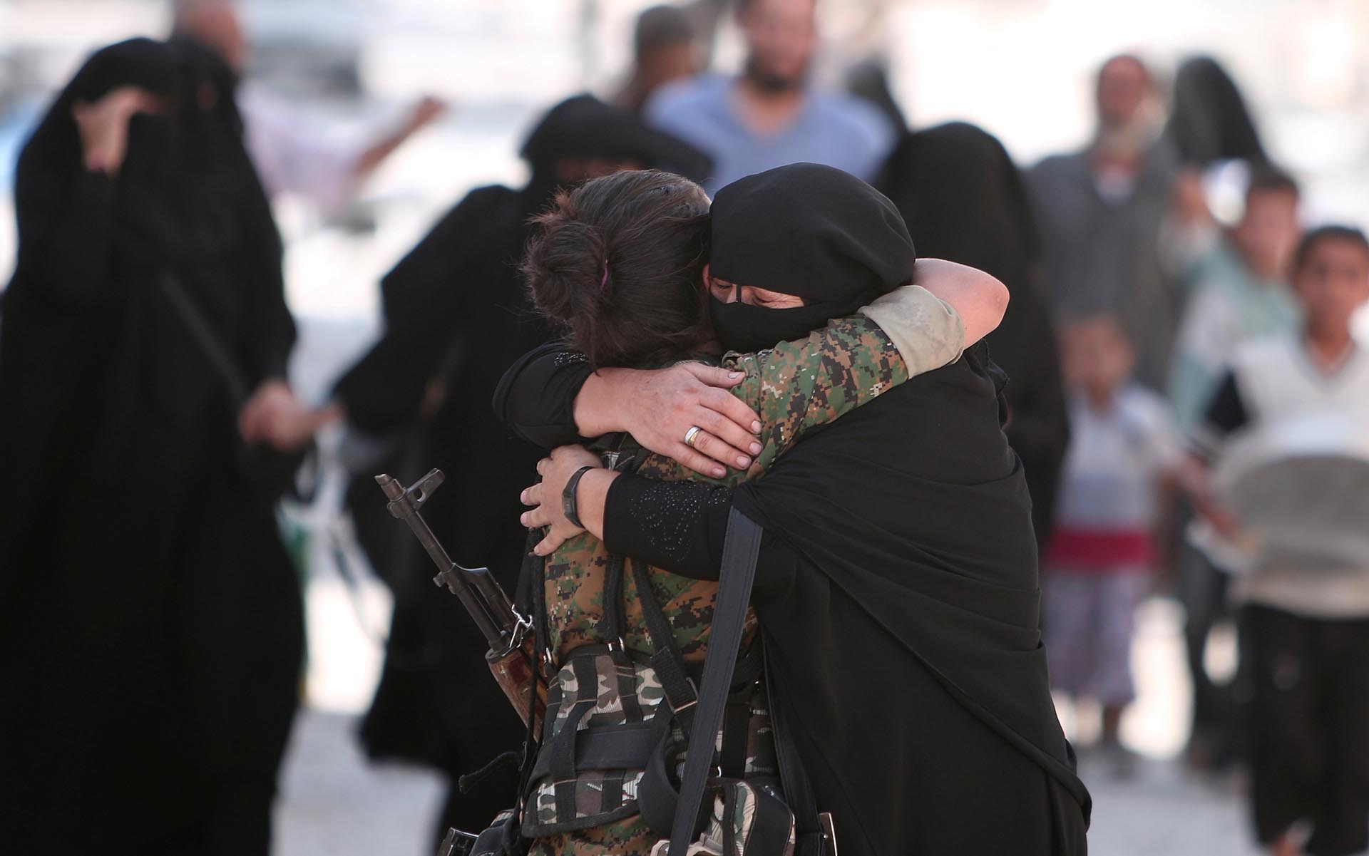 Una mujer abraza a una soldado de las Fuerzas Democráticas de Siria (SDF) luego de ser evacuada de la ciudad de Manbij tras dos años y medio de sufrir el terror de ISIS