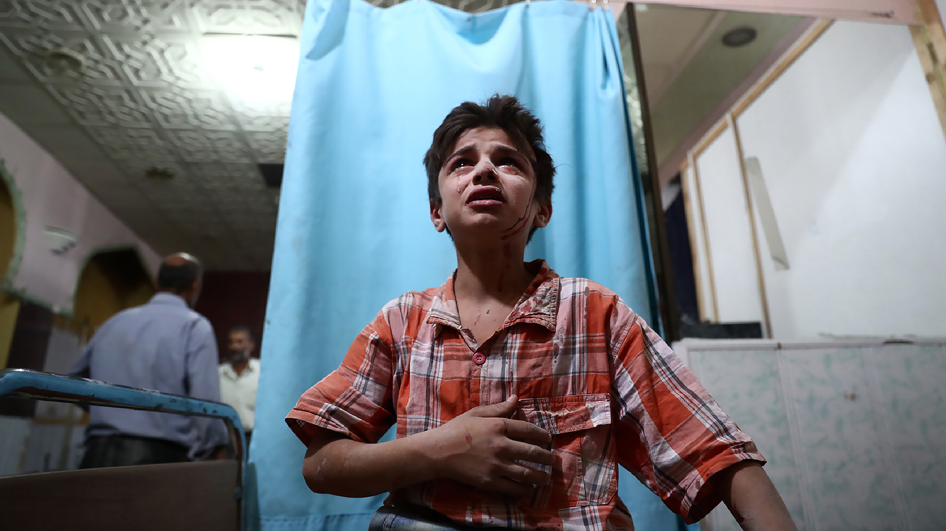 Un niño sirio herido llora mientras espera que lo atiendan en un hospital de campaña después de un ataque aéreo en la ciudad de Douma. (AFP)