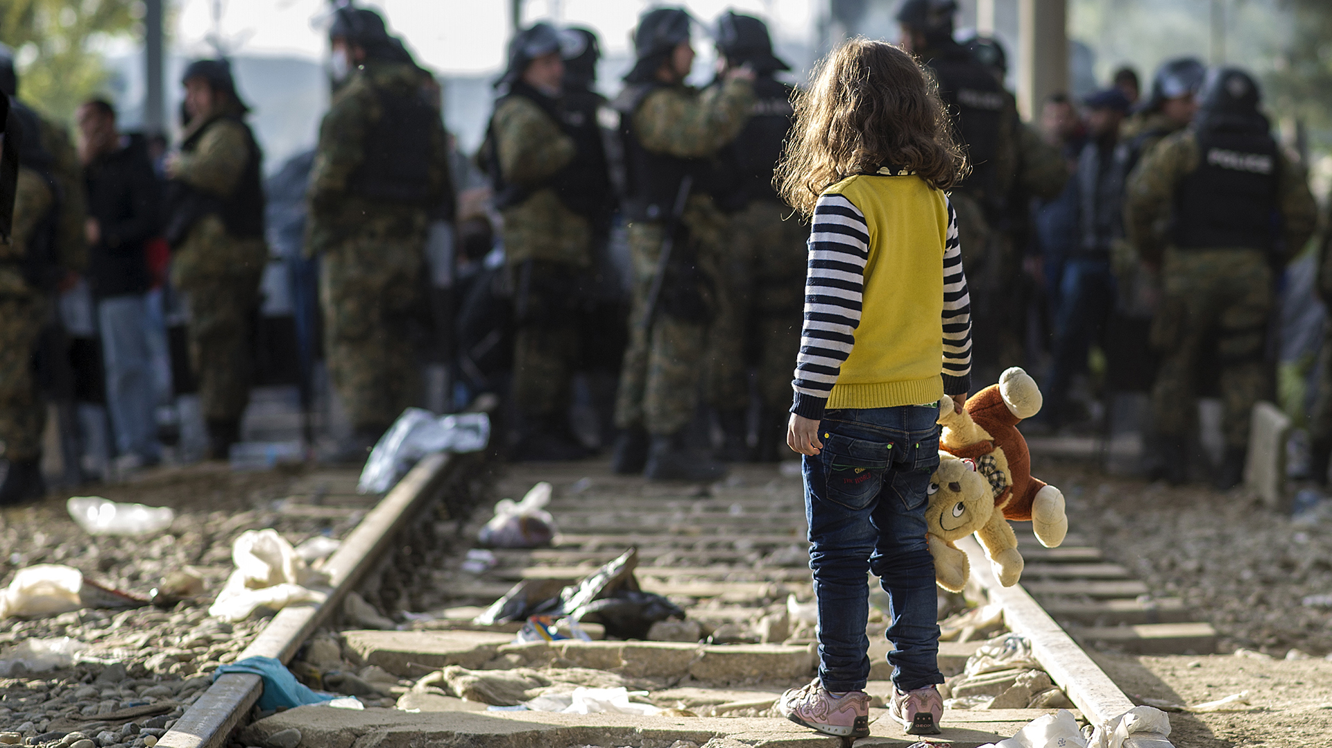 Una niña observa a la policía macedonia mientras impide el paso de inmigrantes hacia Grecia. (AFP)