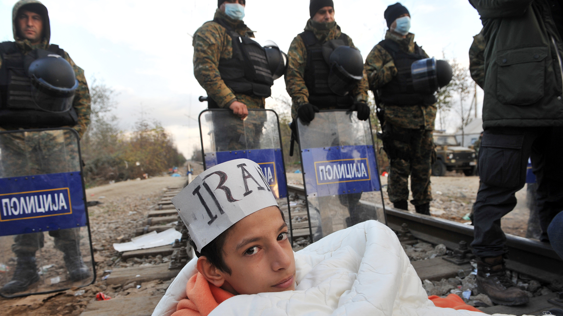 Un refugiado iraní se tiende sobre las vías en la frontera de Macedonia, como protesta para lograr que lo dejen ingresar a Grecia junto asu familia. / AFP / SAKIS MITROLIDIS