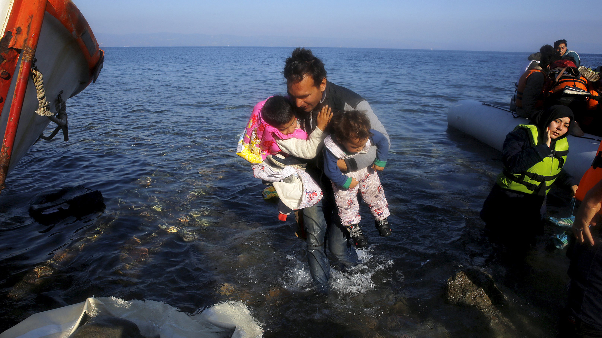 Un inmigrante afgano carga sus hijos luego de arribar en un bote sobrecargado a la isla groga de Lesbos. REUTERS/Yannis Behrakis