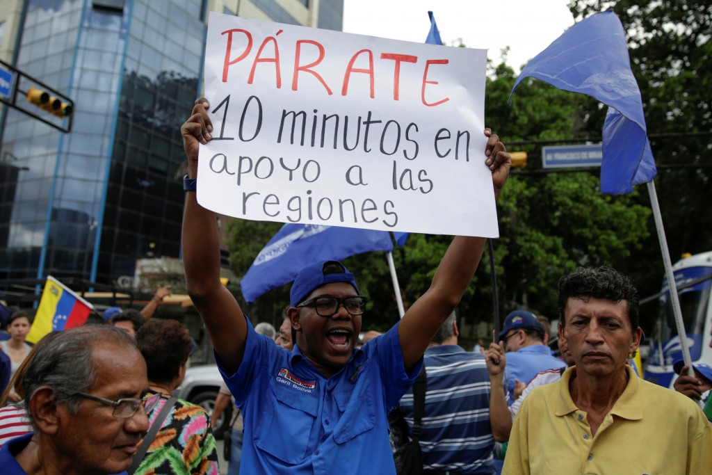 An opposition supporter holds a placard that reads "Standstill for 10 minutes in support of the regions" during a gathering to demand a referendum to remove Venezuela's President Nicolas Maduro in Caracas, Venezuela September 7, 2016. REUTERS/Marco Bello