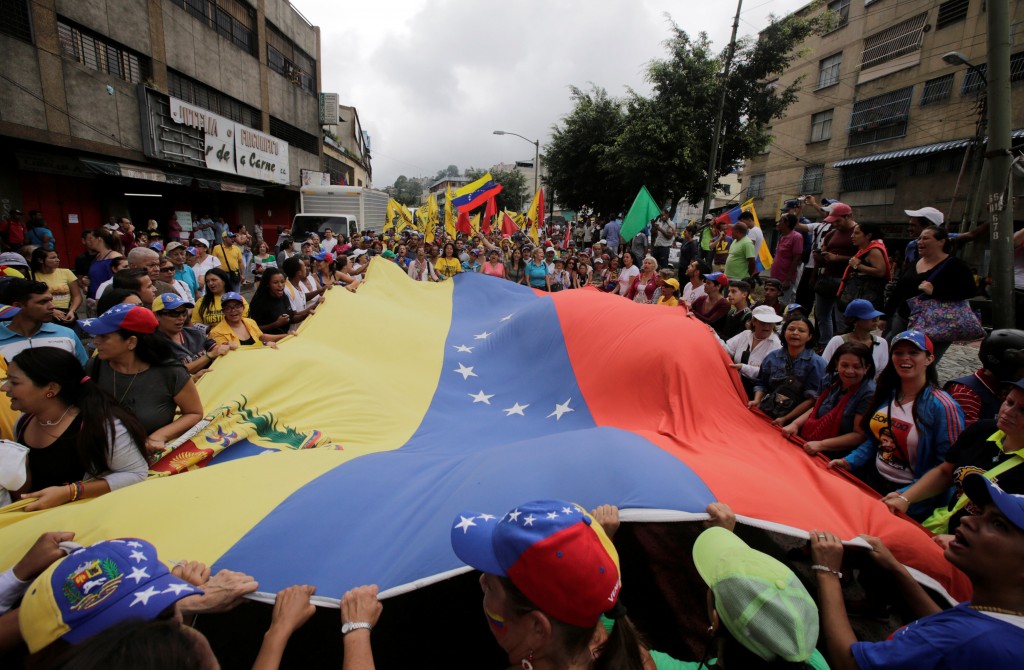 Opposition supporters carry a Venezuelan flag along the streets as they take part in a rally to demand a referendum to remove Venezuela's President Nicolas Maduro, in Los Teques near Caracas, Venezuela, September 7, 2016. REUTERS/Henry Romero