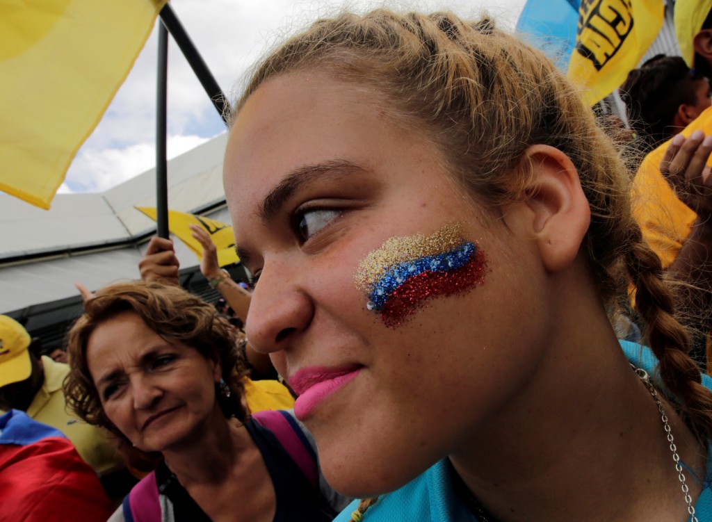 A opposition supporter with her face painted with the colors of Venezuela's flag is seen as she takes part in a rally to demand a referendum to remove Venezuela's President Nicolas Maduro, in Los Teques near Caracas, Venezuela, September 7, 2016. REUTERS/Henry Romero