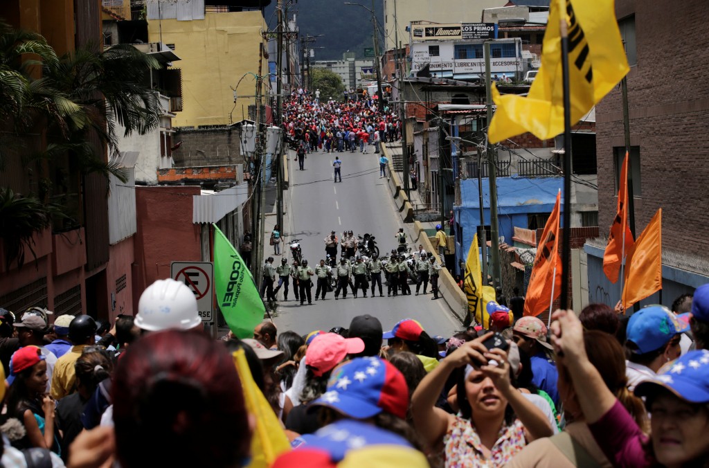 Supporters of Venezuelan President Nicolas Maduro (top) shout slogans in the streets while opposition supporters (below) take part in a rally to demand a referendum to remove Maduro in Los Teques near Caracas, Venezuela, September 7, 2016. REUTERS/Henry Romero TPX IMAGES OF THE DAY