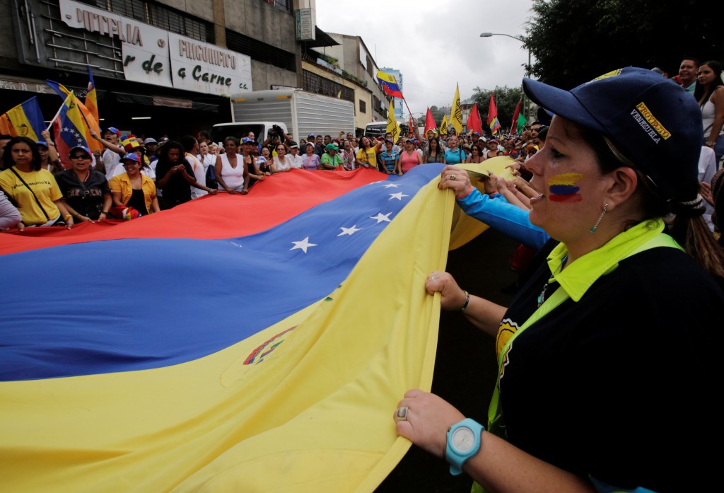 Opposition supporters carry a Venezuela flag as they take part in a rally to demand a referendum to remove Venezuela's President Nicolas Maduro in Los Teques near Caracas, Venezuela, September 7, 2016. REUTERS/Henry Romero