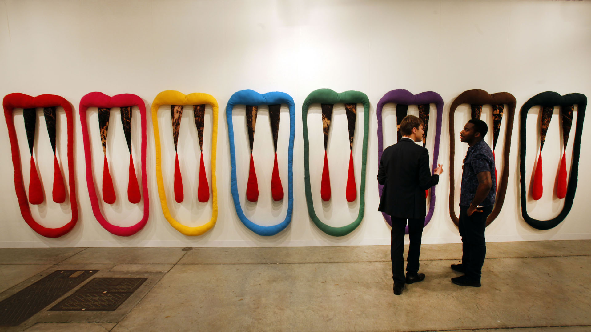 Art Bael Miami, uno de los eventos más esperados del año. Dos personas observan una obra de la feria en el año 2016 (AP Photo/Wilfredo Lee)
