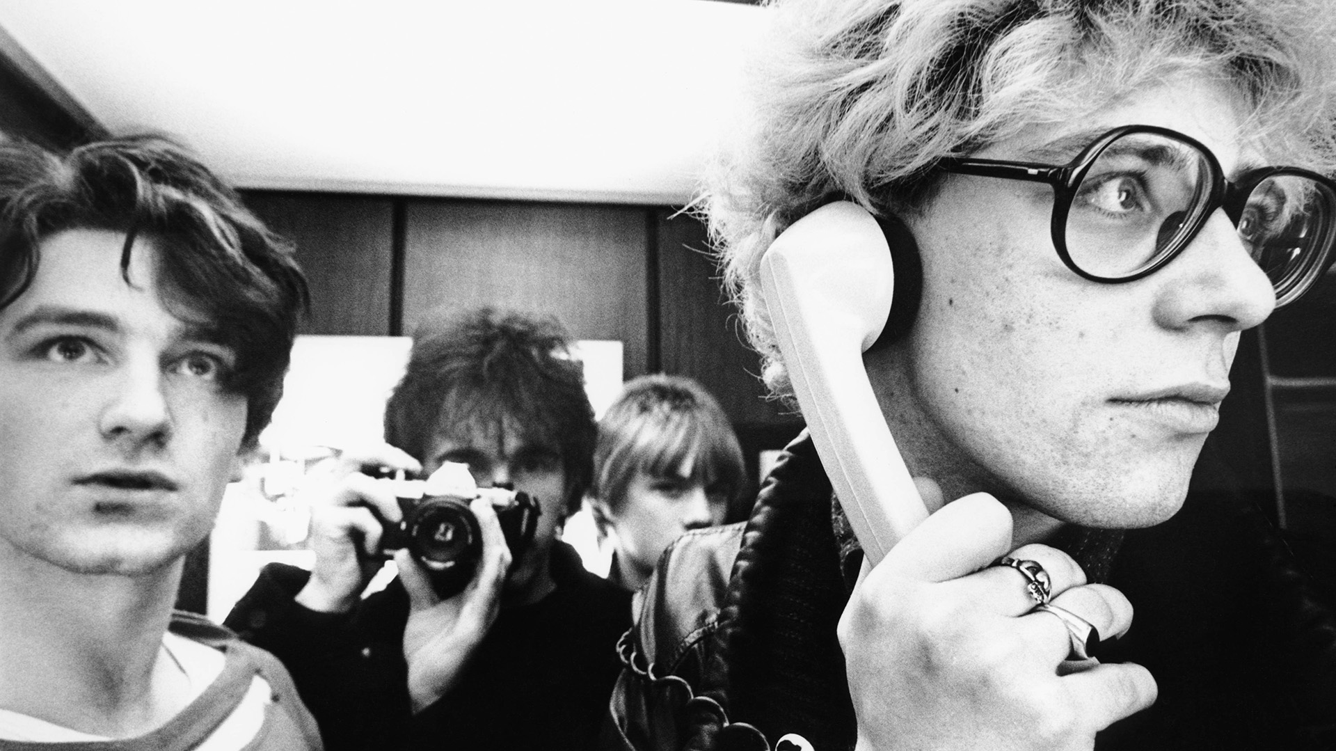 De izuierda a derecha: Bono, The Edge (sosteniendo la cámara), Larry Mullen Jr y Adam Clayton (al teléfono)