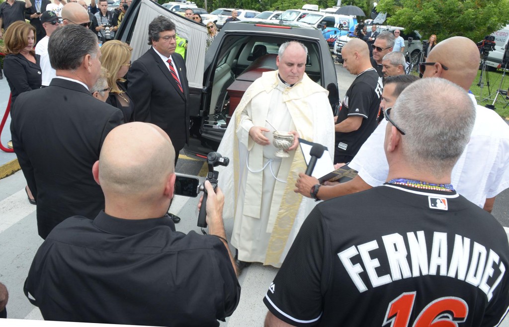 El rector de la Ermita de la Caridad del Cobre, el padre Juan Rumín Domínguez, se prepara para bendecir el ataúd del jugador cubano (EFE)