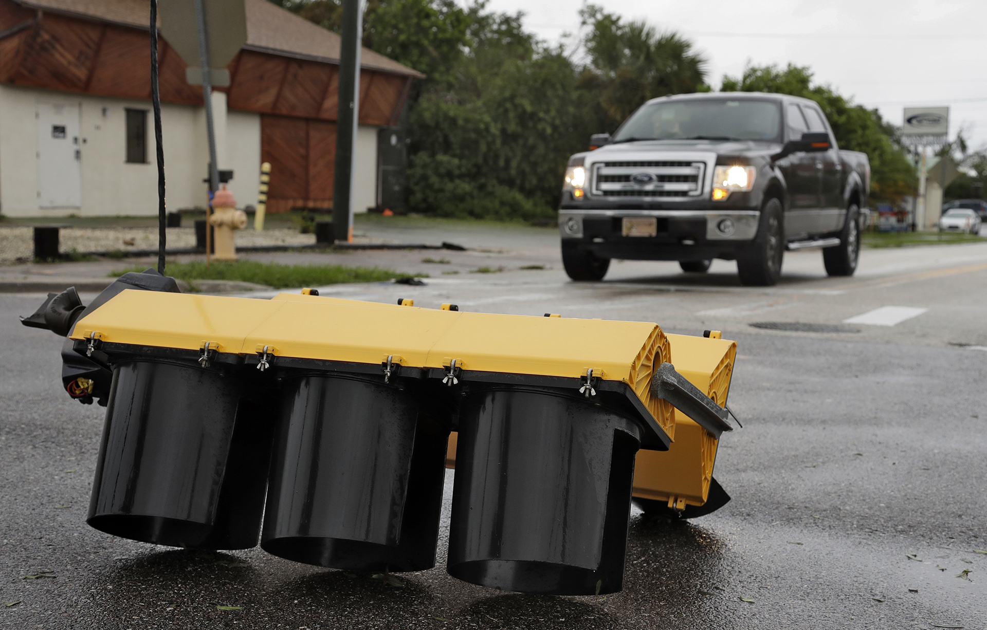 Algunos automóviles se detienen ante un semáforo derribado por el huracán en Cocoa Village (AP Photo/Chris O’Meara)