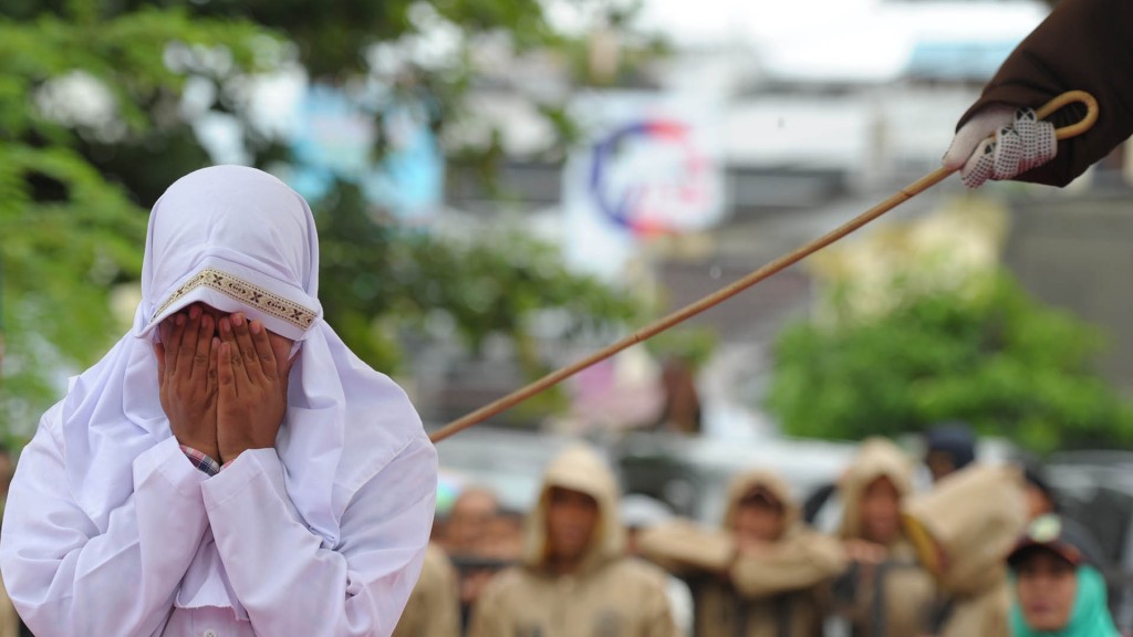 A Muslim woman gets caned 23 strokes after being caught in close proximity with her boyfriend in Banda Aceh on October 17, 2016. Out of seven couples caught spending time together outside marriage, 13 were caned while one woman was spared after it was discovered that she was pregnant. Indonesia's Aceh province has gained international infamy for its strict Islamic laws. / AFP PHOTO / CHAIDEER MAHYUDDIN / ìThe erroneous mention[s] appearing in the metadata of this photo by CHAIDEER MAHYUDDIN has been modified in AFP systems in the following manner: [WOMAN] instead of [GIRL]. Please immediately remove the erroneous mention[s] from all your online services and delete it (them) from your servers. If you have been authorized by AFP to distribute it (them) to third parties, please ensure that the same actions are carried out by them. Failure to promptly comply with these instructions will entail liability on your part for any continued or post notification usage. Therefore we thank you very much for all your attention and prompt action. We are sorry for the inconvenience this notification may cause and remain at your disposal for any further information you may require.î