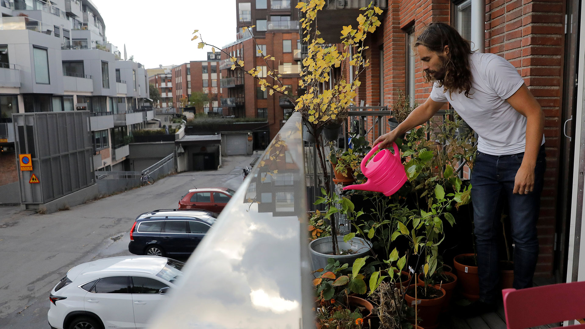 Daniel Jager riega plantas en el balcón de su departamento de Estocolmo, que transformó en una mini huerta (Reuters)