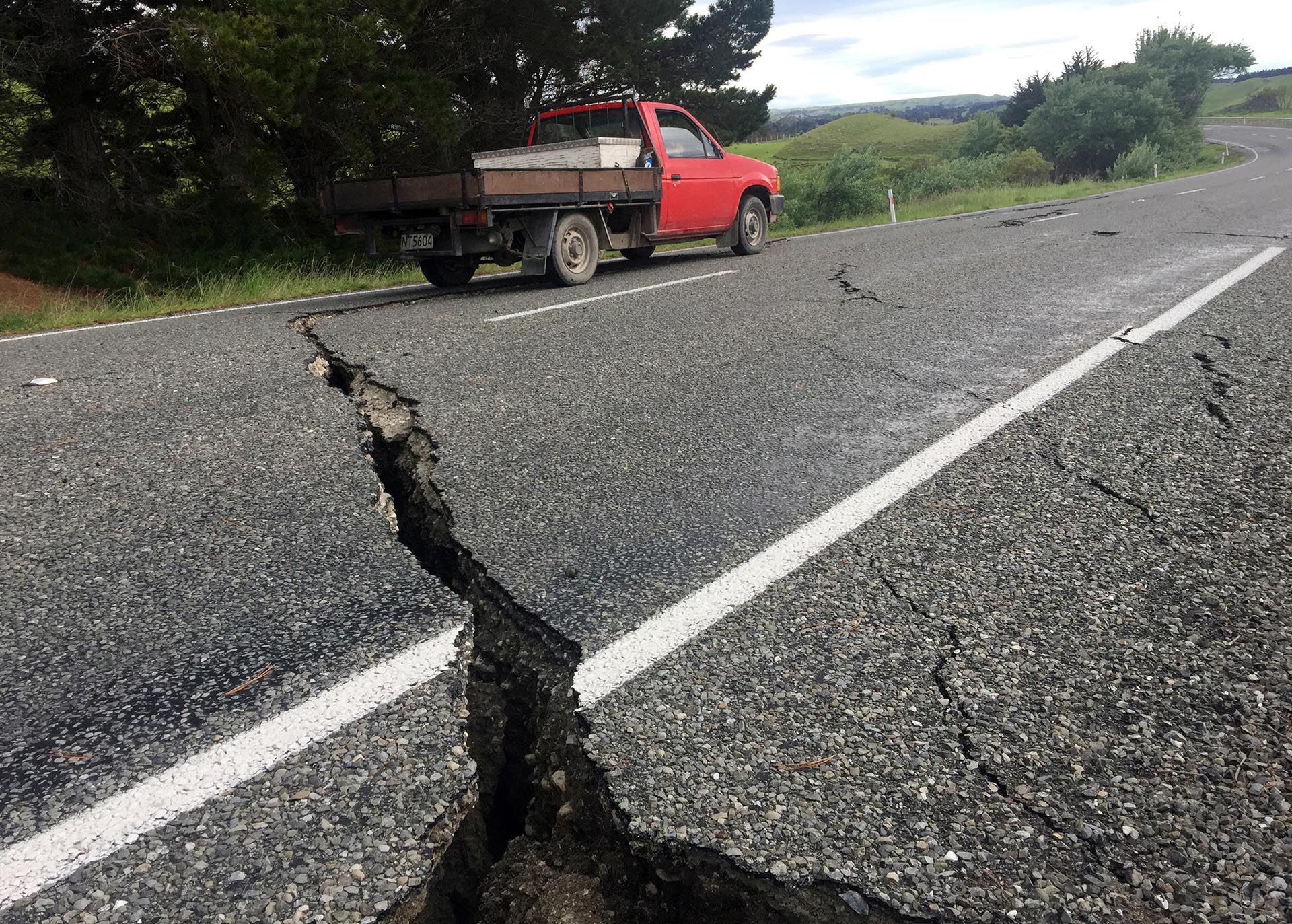 Un camión conduce sobre la carretera fracturada al sur de la ciudad de Ward