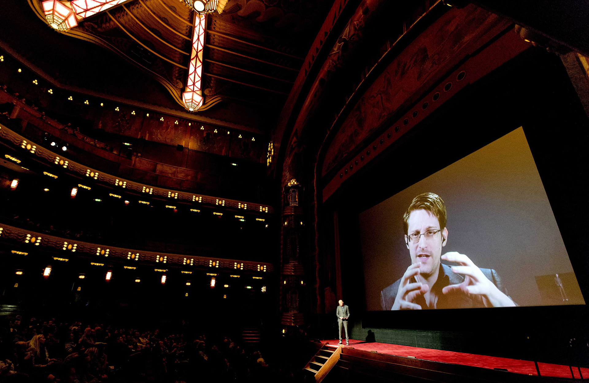 Edward Snowden habla al público reunido en un teatro de Amsterdam en una teleconferencia desde Rusa para el estreno de la película “Snowden” en 2016 (EFE/Sander Koning)