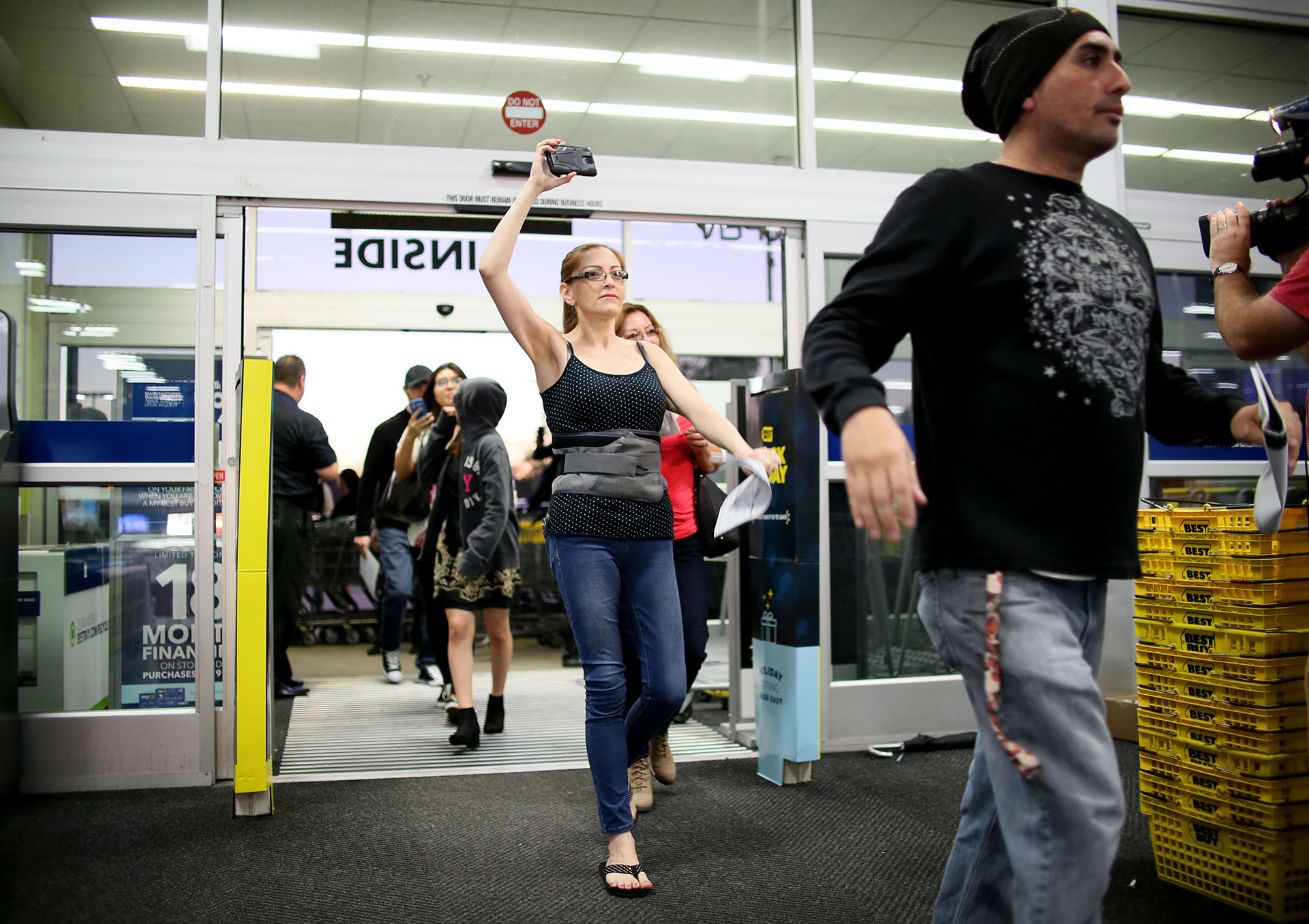 Finalmente se abre la puerta de Best Buy en San Diego y los compradores acceden felices. Algunos graban el momento con sus teléfonos celulares (AFP PHOTO / Sandy Huffaker)