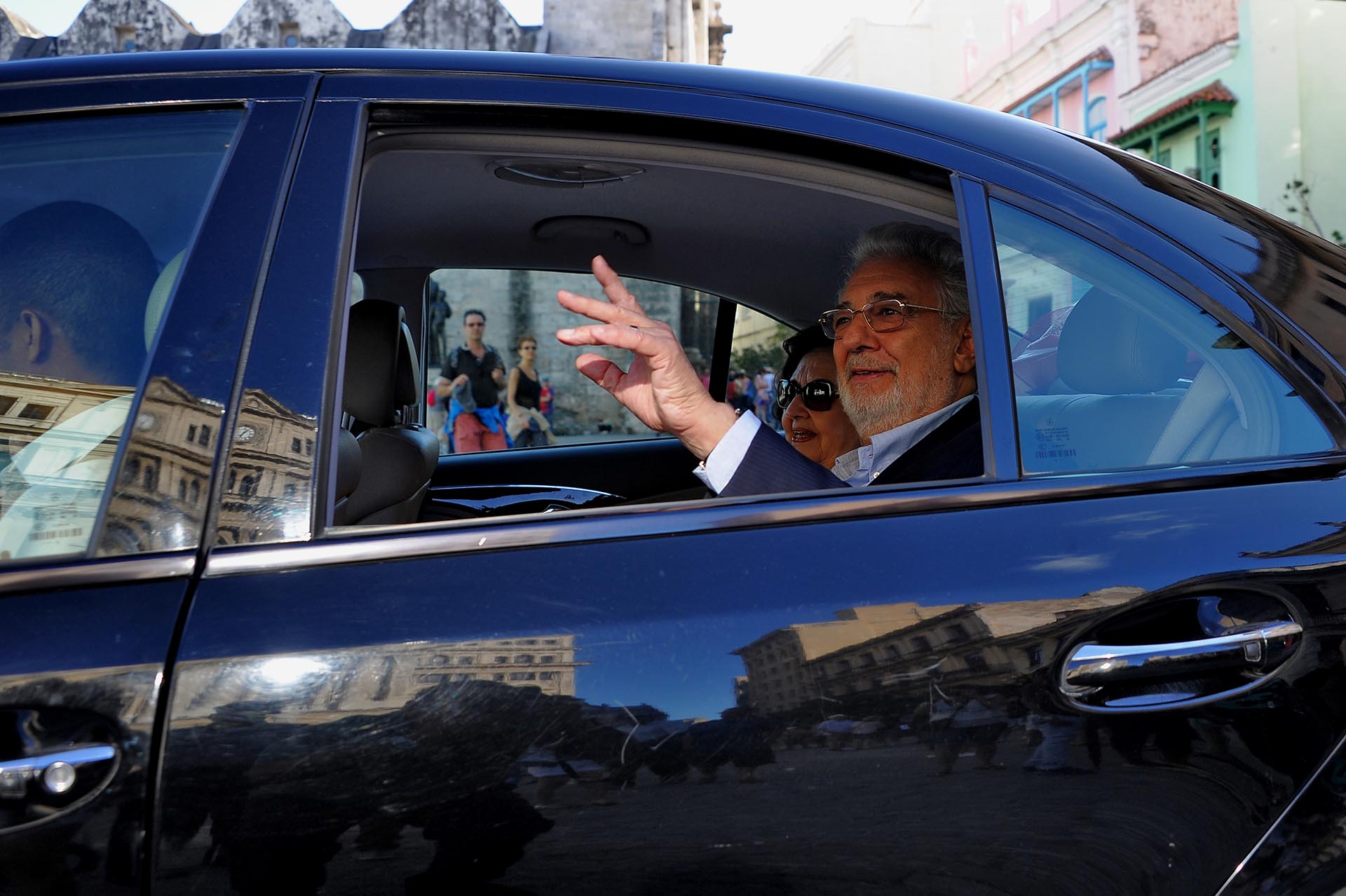 El tenor español Placido Domingo hace un gesto desde un automóvil cuando sale del Hotel San Felipe en La Habana, el 24 de noviembre de 2016 / AFP PHOTO / YAMIL LAGE
