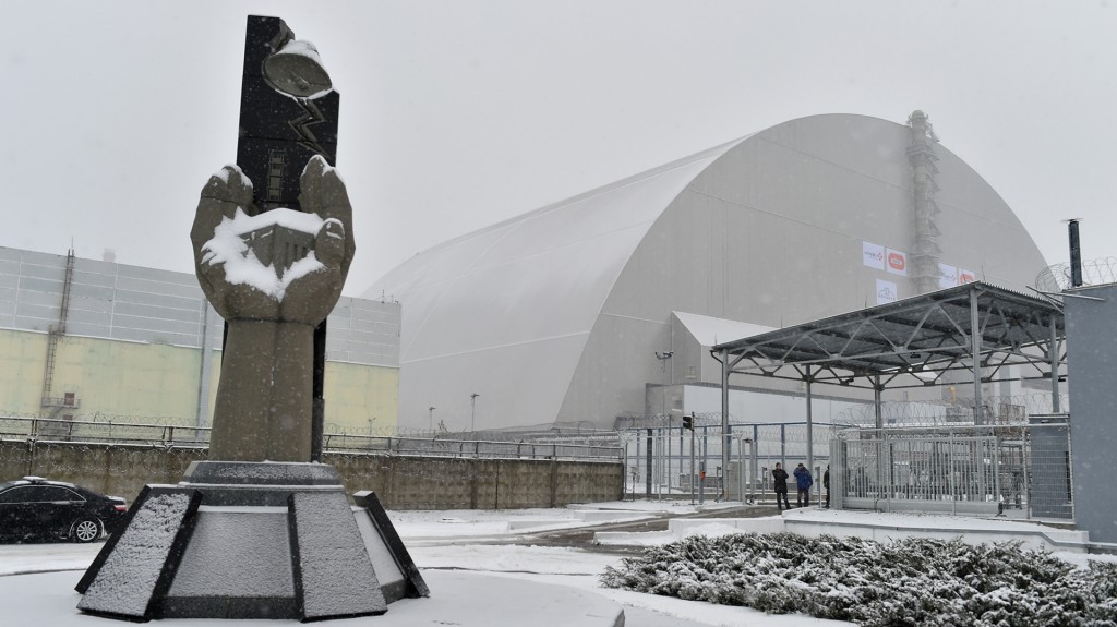 Un monumento a las víctimas en las afueras de los restos de la central nuclear (AFP)