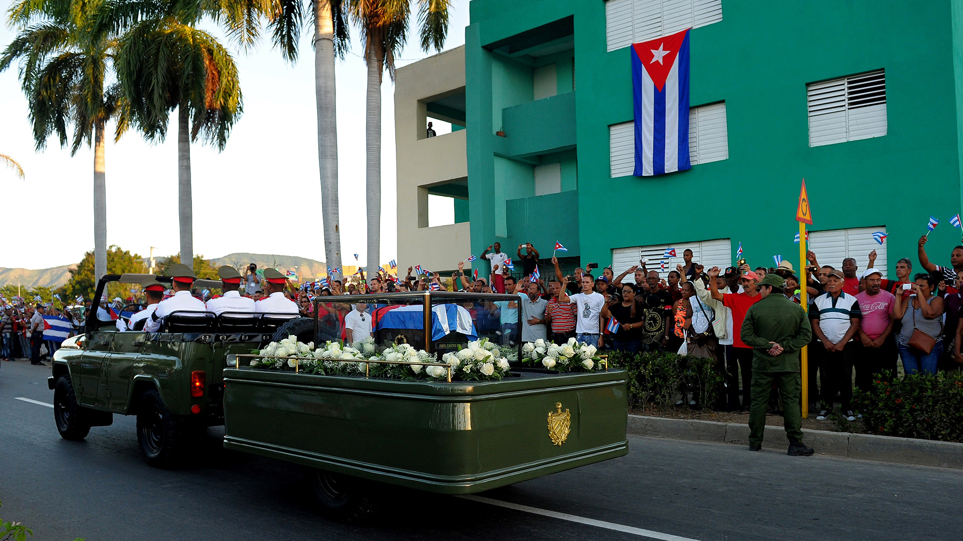 El avance del cortejo fúnebre por la ciudad de Santiago de Cuba fue saludado por miles de personas a ambos lados de las calles