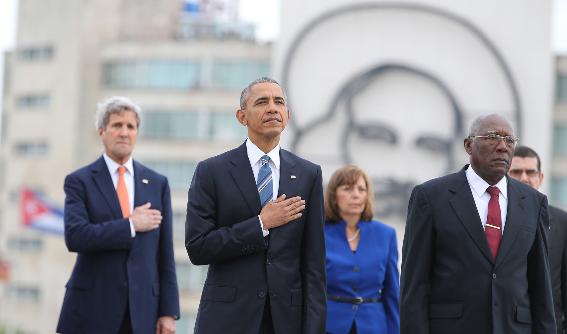 El presidente Barack Obama, y el secretario de Estado John Kerry, escuchan el himno nacional de EEUU durante una ceremonia en el monumento a José Martí en la Plaza de la Revolución en La Habana, Cuba, el lunes 21 de marzo de 2016. A la derecha está Salvador Valdés, vicepresidente del Consejo de Estado de Cuba. (Foto AP / Enric Martí)