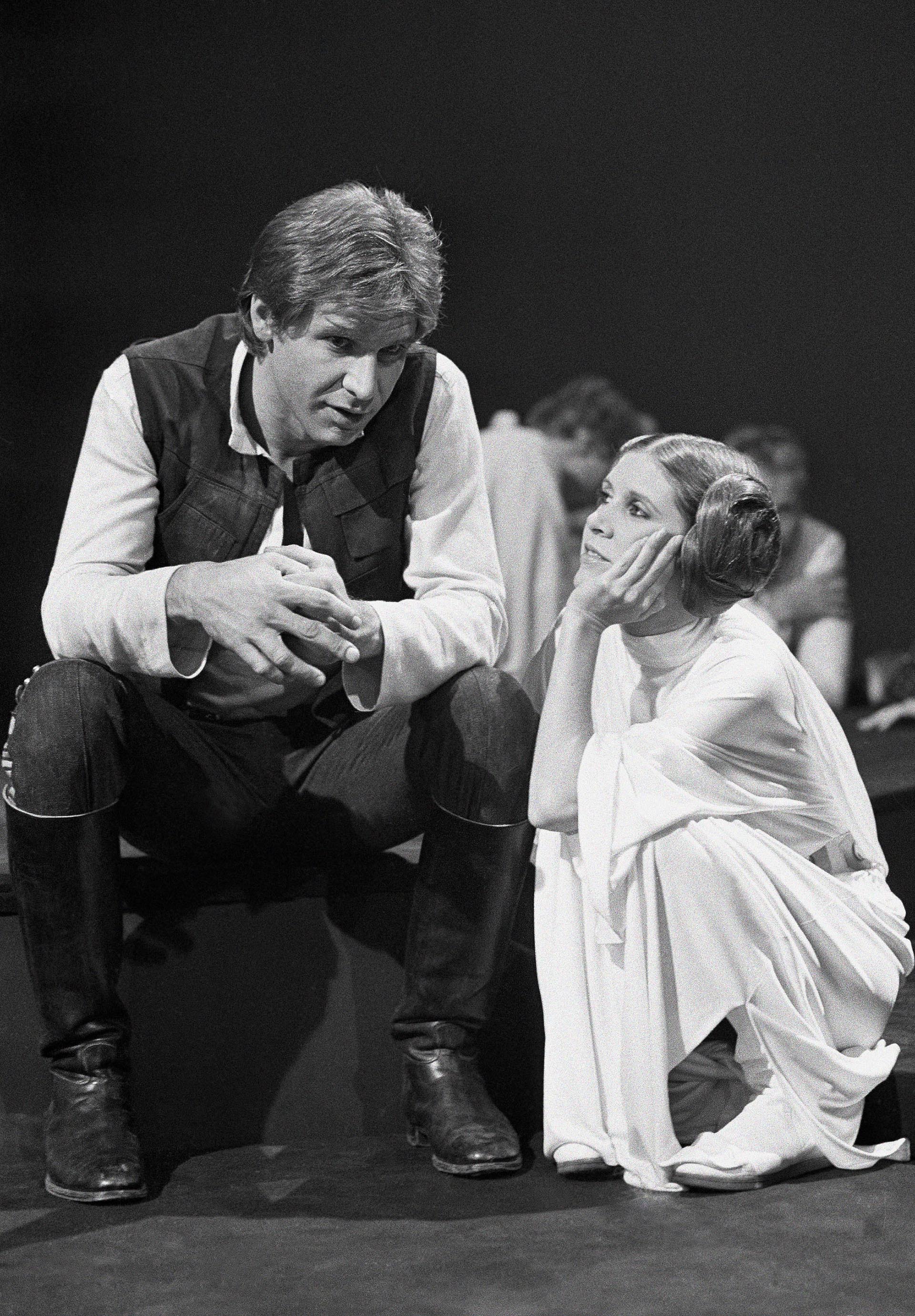 Harrison Ford habla con Carrie Fisher durante un descanso en la filmación de la película de Star Wars (AP Photo/George Brich, File)