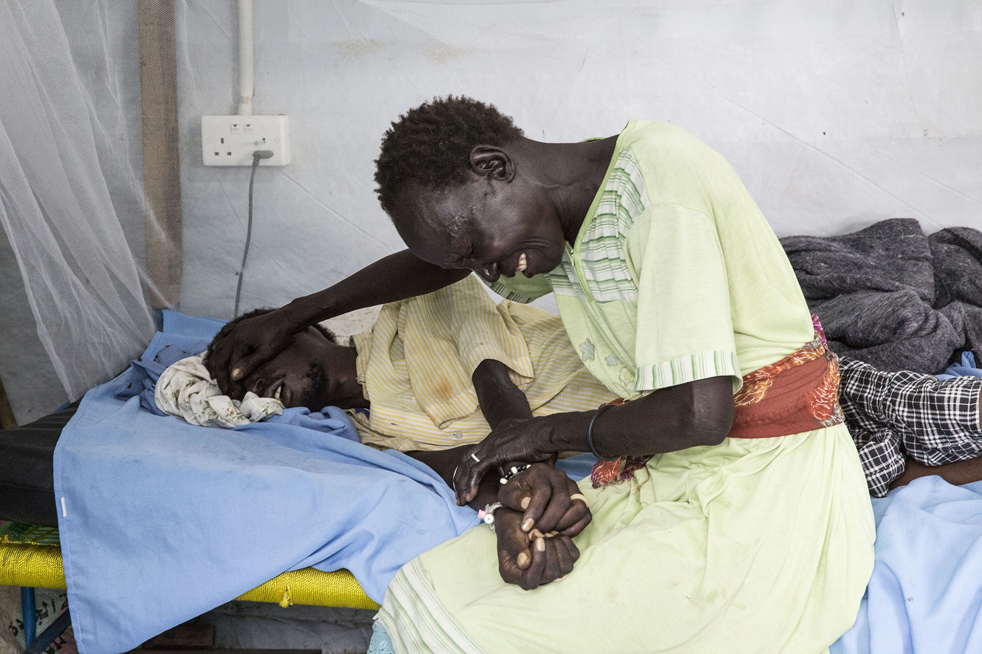Una mujer llorando por su familiar enfermo en el hospital de MSF en el Centro de Protección de Civiles de las Naciones Unidas en Malakal, Sudán del Sur (©Anna Surinyach)
