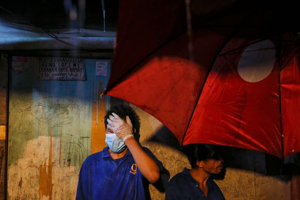 Funerarios se preparan para entrar en una casa de Manila, donde la policía y los testigos dijeron que cinco sospechosos de drogas fueron muertos a tiros por pistoleros no identificados (Reuters)