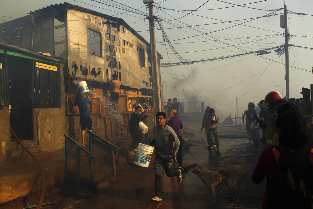 Vecinos ayudan a combatir un incendio forestal en el sector de Playa Ancha en la ciudad de Valparaíso (Chile) que afectó a viviendas y vecinos del sector (EFE)