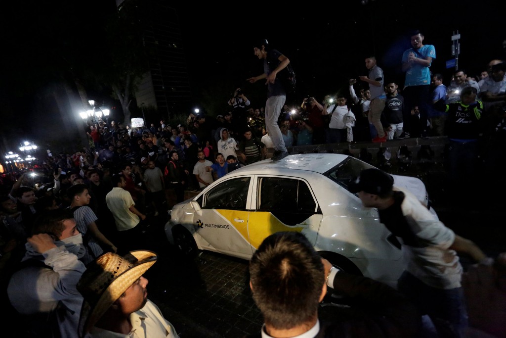 Mientras ocurrían los enfrentamientos en el centro, decenas de personas saquearon dos sucursales de tiendas de muebles en el noroeste de la ciudad (Reuters)