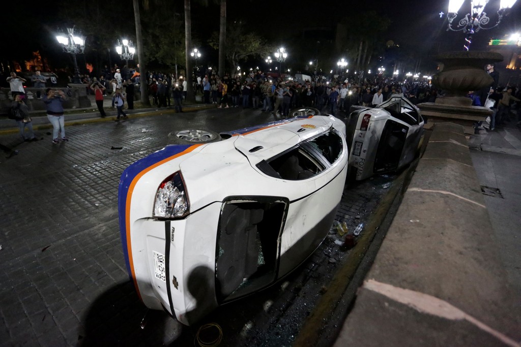 Los manifestantes también utilizaron las vallas metálicas colocadas por la misma policía para lanzarlas contra los agentes y destrozaron vehículos (Reuters)