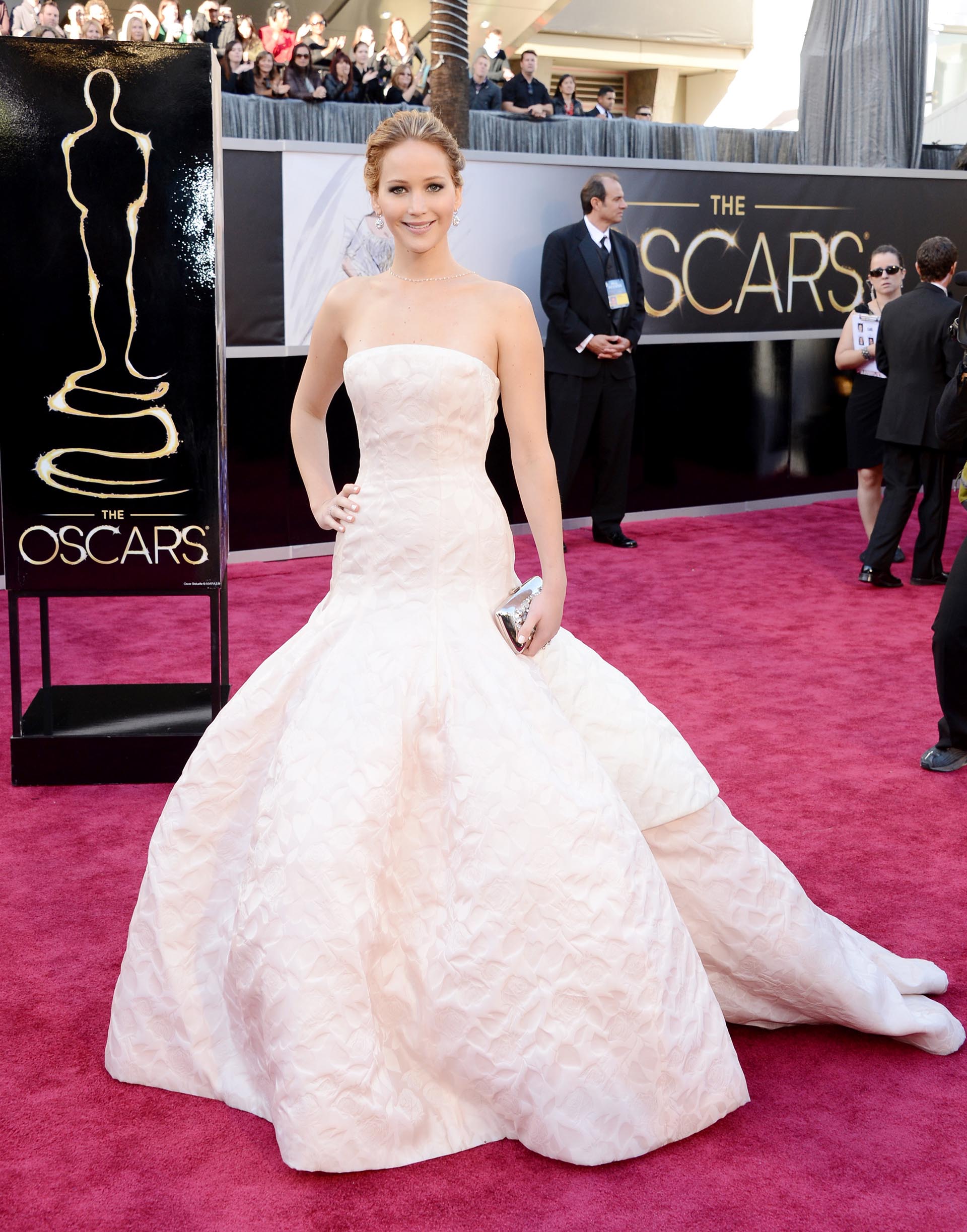El vestido de Jennifer Lawrence tuvo varios bloopers. Uno de ellos fue que por sus kilométricos metros de tela se cayó frente al escenario cuando se levantó para recibir el premio de Mejor Actriz. Para la entrega del 2013 la actriz eligió un strapless en diseño sirena con falda amplia. El color elegido: un rosa bebé y tela tramada.