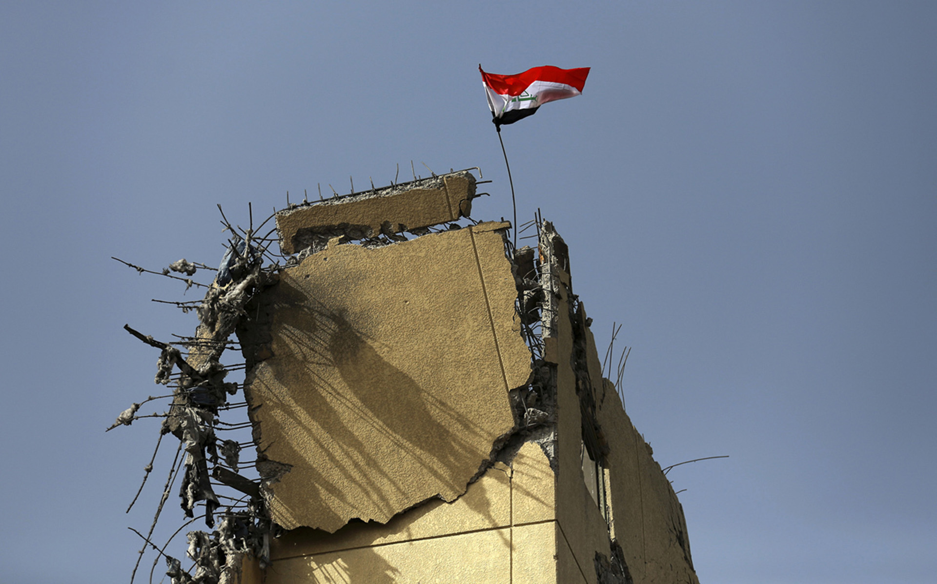 La bandera de Irak flamea sobre los restos del hospital al Salam, donde se libró la batalla más dura durante la recaptura del este de Mosul (AP)