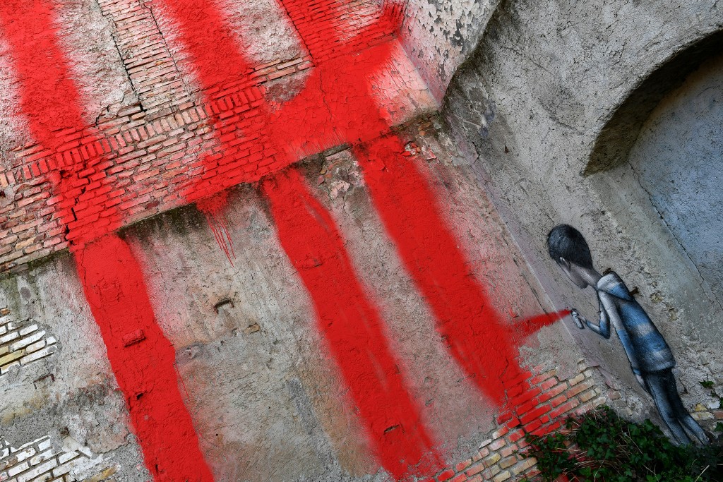 El detalle de la firma del artista, con una especie de “autorrretrato” (AFP PHOTO / Alberto PIZZOLI)