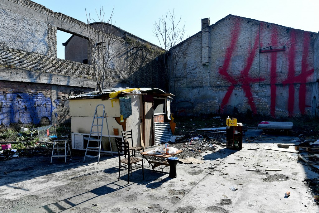 La casa de una familia de refugiados en la ex fábrica Mira Lanza. Al fondo, la firma de SETH (AFP PHOTO / Alberto PIZZOLI)