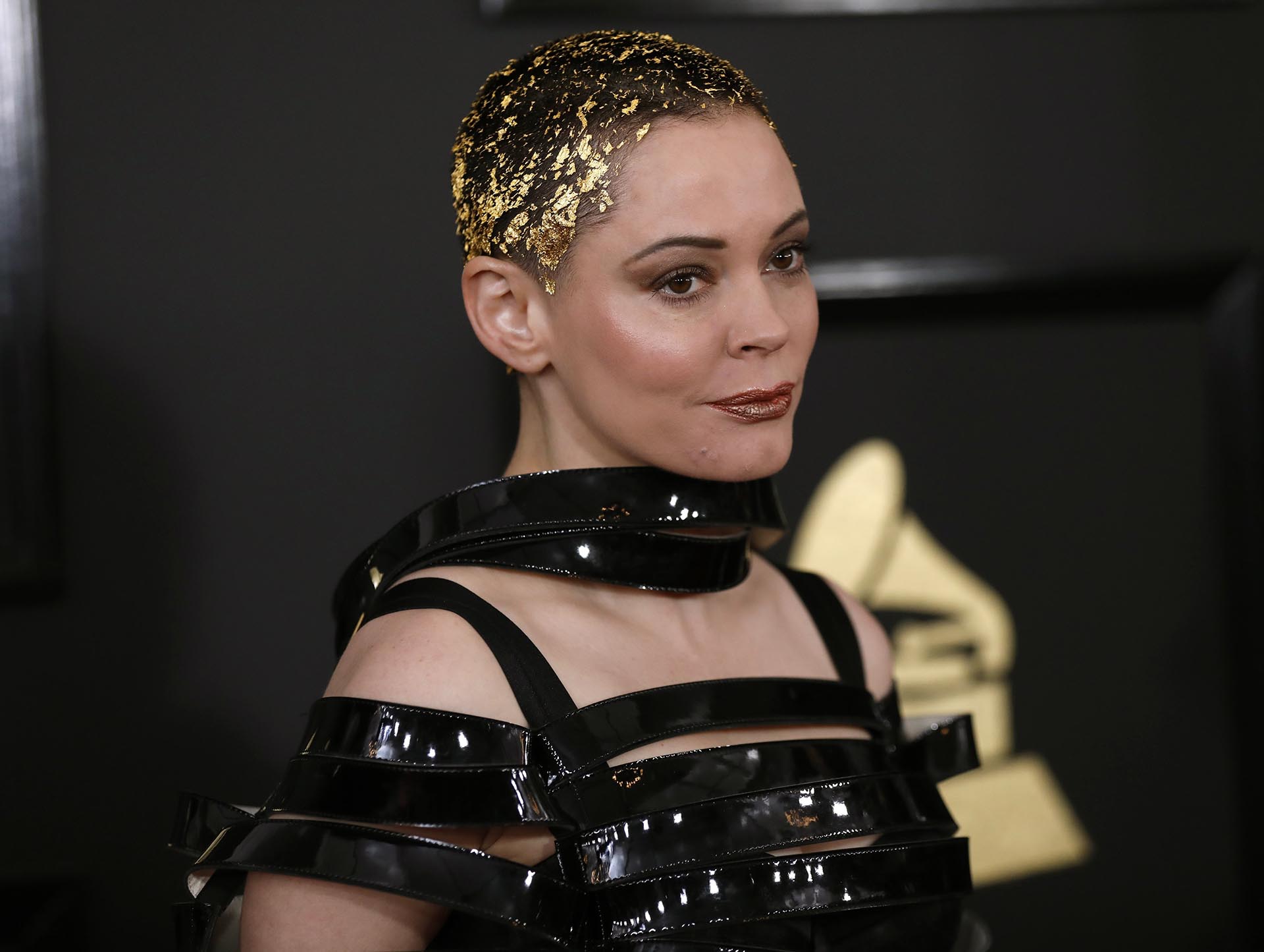 La actriz Rose McGowan impactó con su peinado con papel dorado en el cabello corto y el atuendo con cintas acharoladas de vinilo en la parte superior del top