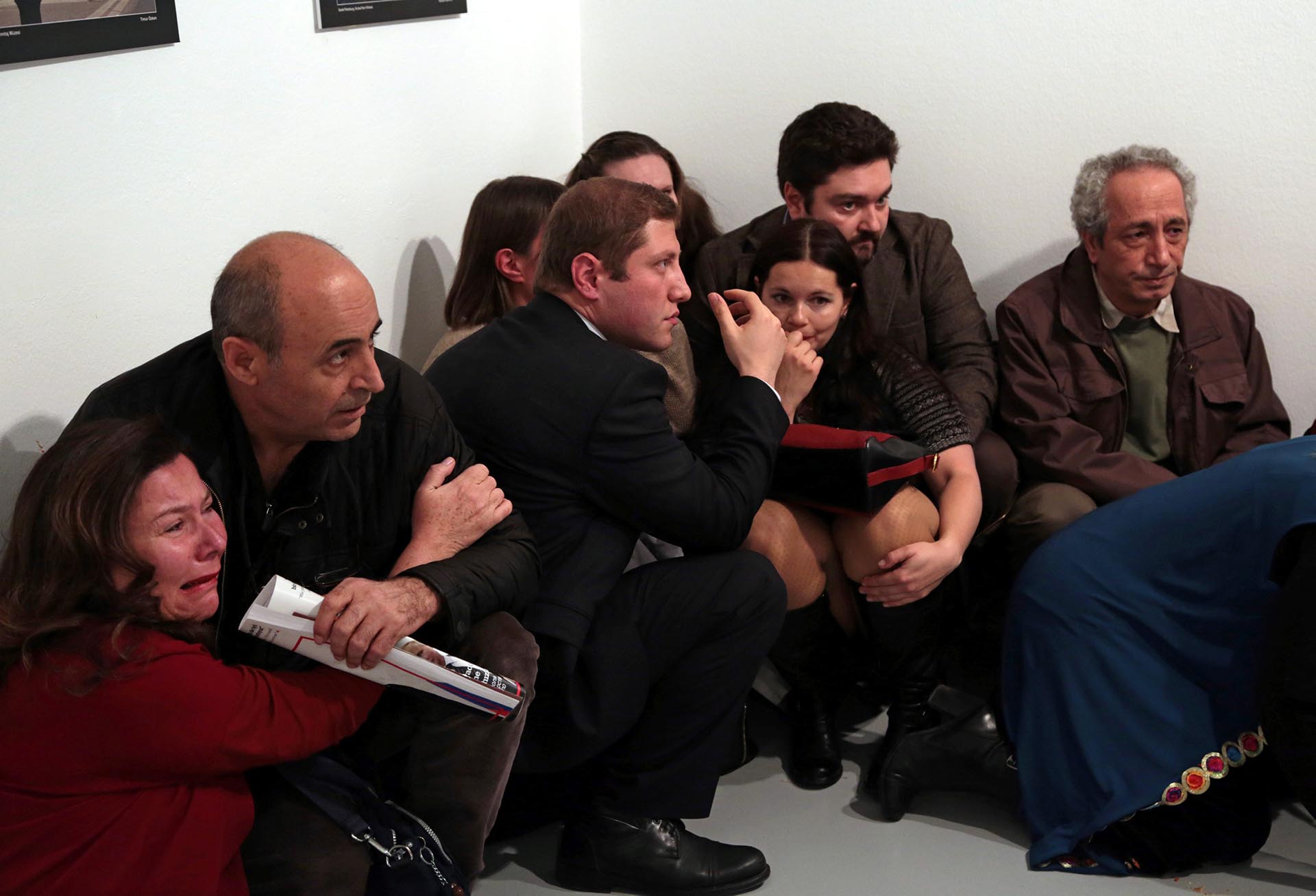 Los asistentes al evento se cubren durante la balacera. Burhan Ozbilici, The Associated Press
