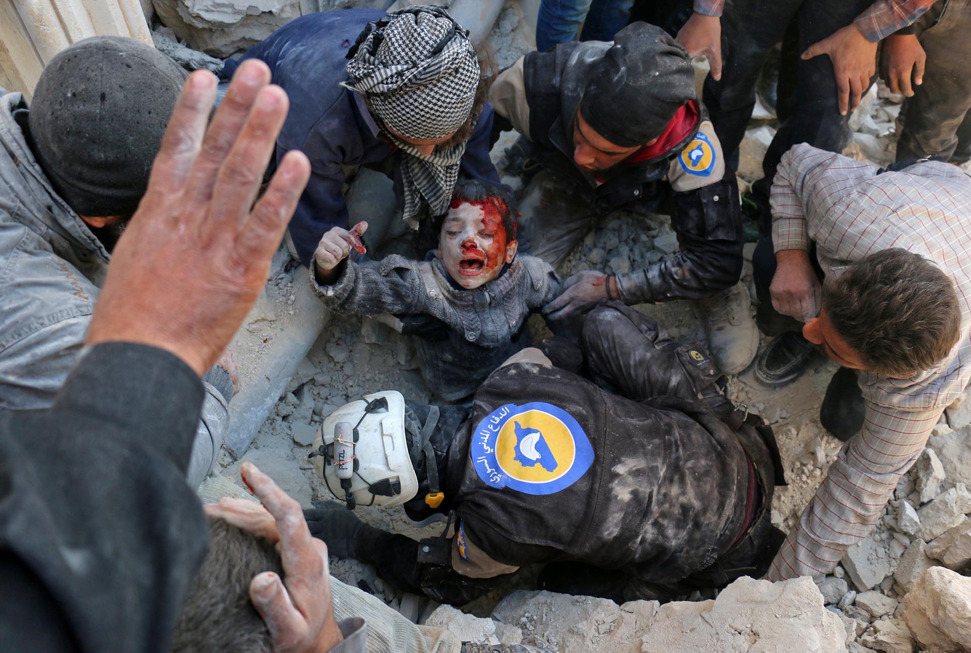 Spot News, segundo premio. Los cascos blancos rescatan a un niño de entre los escombros luego de un ataque con barriles bomba en el barrio de Bab al Nairab, en Alepo, el 24 de noviembre de 2016. Ameer Alhalbi, Agence France-Presse