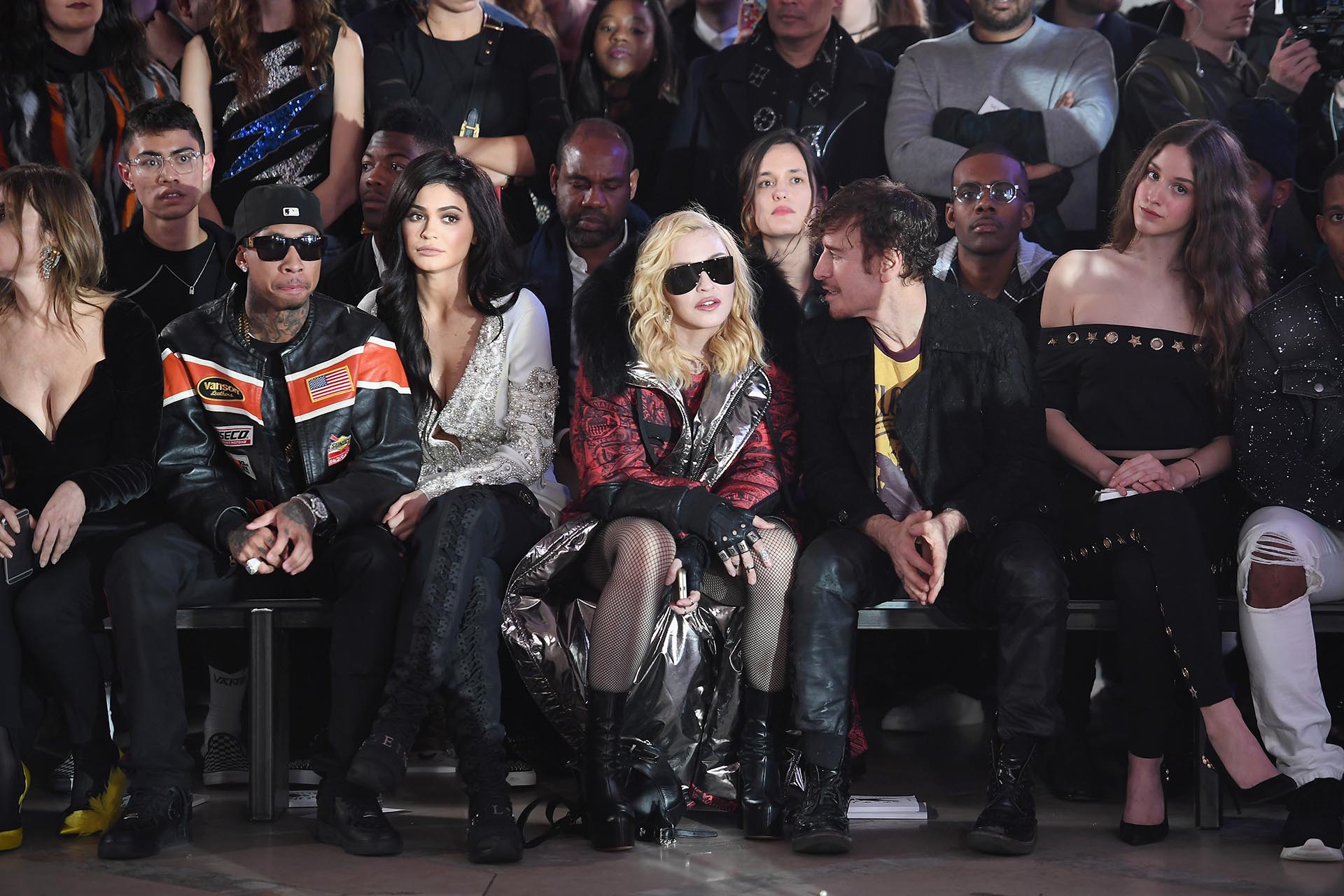 Vestida con un abrigo de capucha, medias de red, guantes, botas y grandes anteojos negros, Madonna se ubicó en la ‘front row’ junto a Tyga, Kylie Jenner y Steven Klein