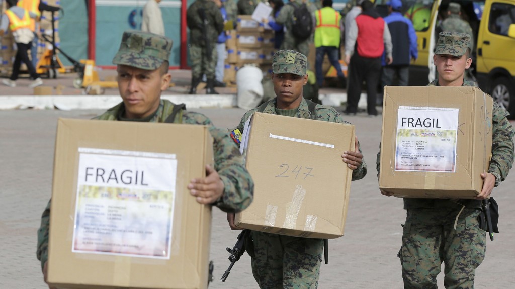 Soldados ecuatorianos llevan las urnas electorales que serán distribuidos en Quito (AP)