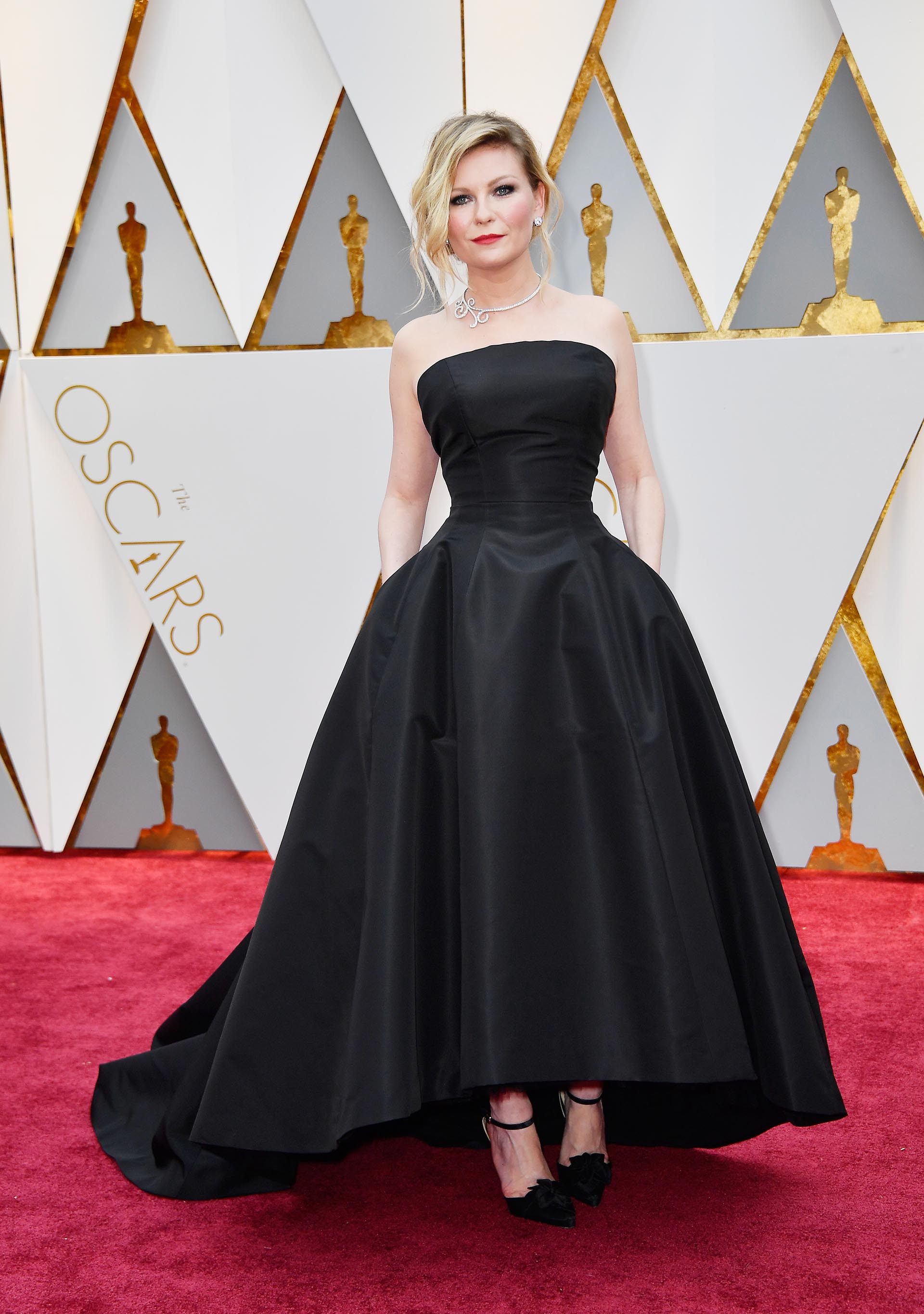 Total black para Kirsten Dunst con un vestido strapless, corte en la cintura y gran falda. Un diseño en color negro de tafetán. La actriz apostó en el 2017 al color que nunca falla. Lo completo con stilettos en punta con pulsera y aplique de flor