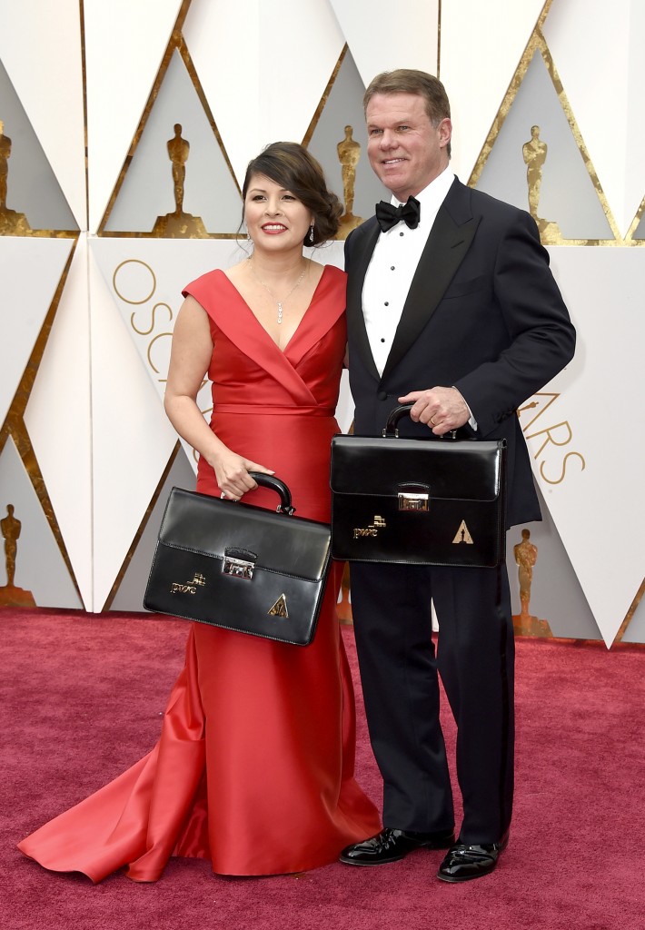 Martha Ruiz y Brian Cullinan en el momento de ingresar al Teatro Dolby con los maletines donde se custodian los resultados de las 24 categorías de los Premios Oscar. (AP)