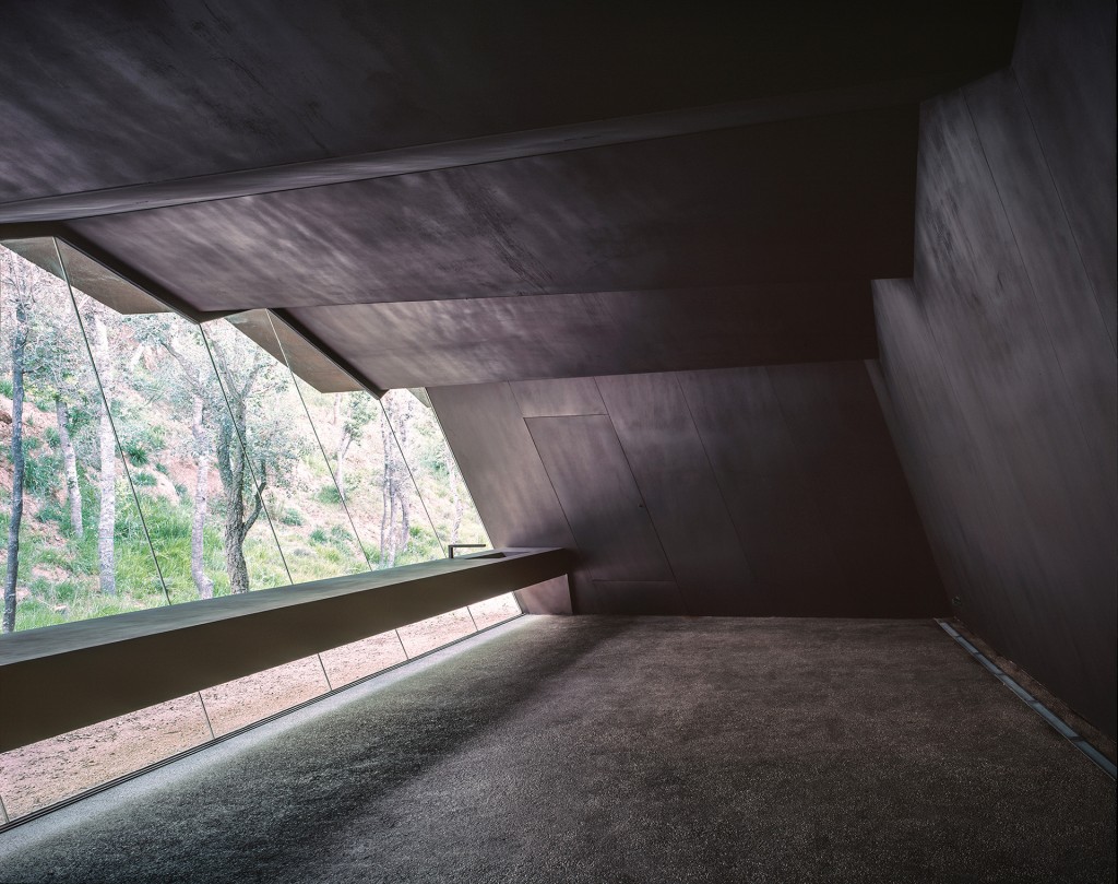 Uno de los “laboratorios” del viñedo Bell Lloc. El techo metálico con pliegues y la pared inclinada crean una gran ventana con vista al bosque, en Girona, España