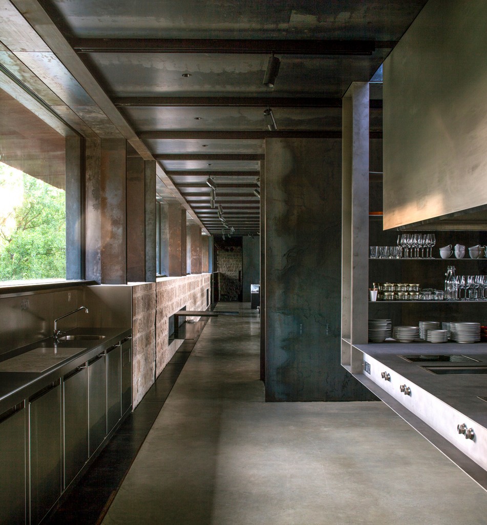 La cocina conduce a un área de exhibición y a un pequeño auditorio. La ventana ofrece vistas contínuas al paisaje verde