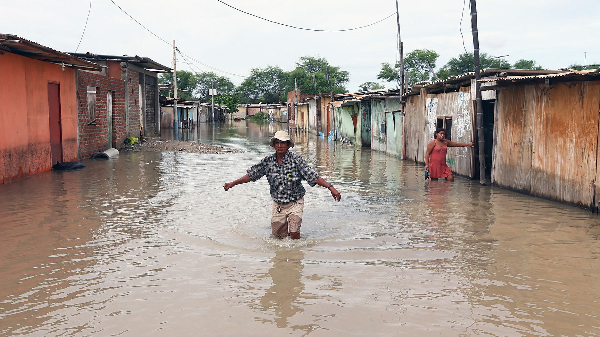 Un poblador trata de cruzar una calle inundada por las lluvias torrenciales caídas sobre el sector de El Indio, en la provincia de Castilla, de la región de Piura, en la costa norte de Perú. Varios ministros de Estado visitan la región Piura, al norte de Perú, para hacer una evaluación de los daños y necesidades de la población, tras las inundaciones y deslizamientos de lodo por las intensas lluvias provocadas por un fenómeno del Niño Costero (EFE)