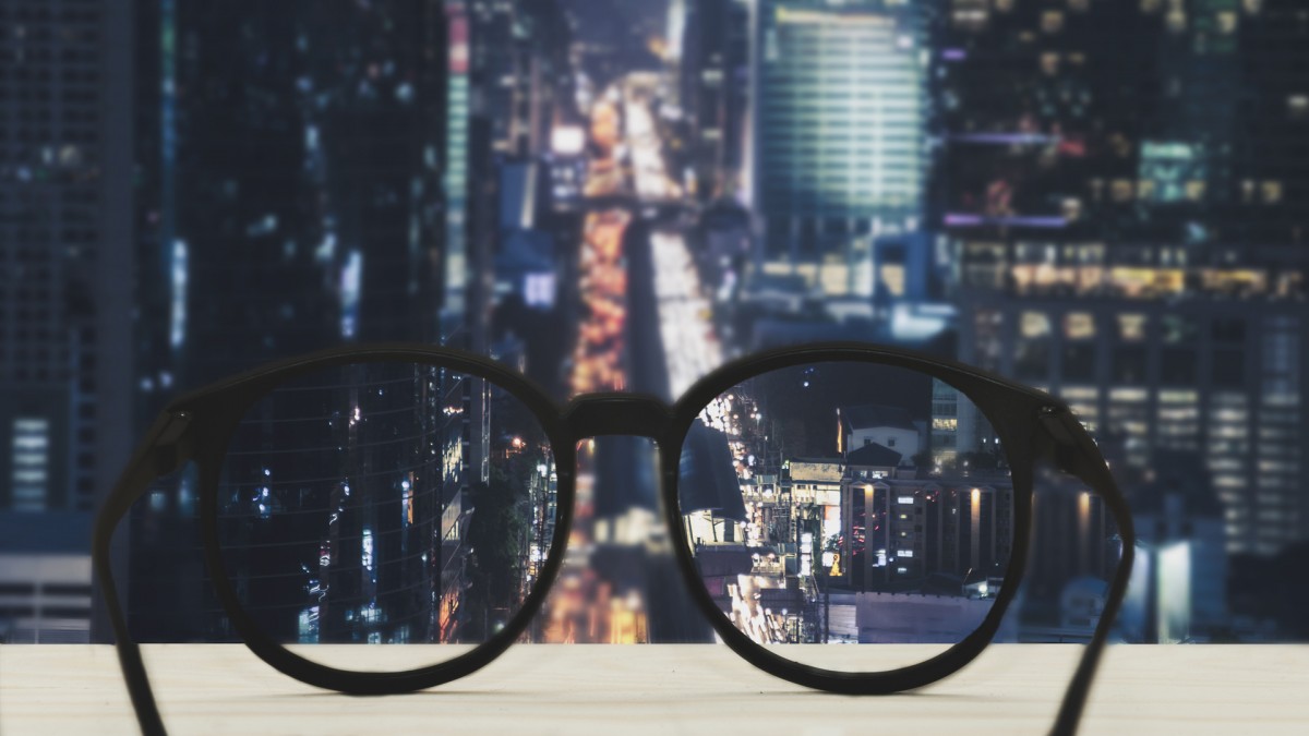 Glasses with clear vision of night cityscape focused